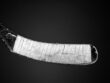 A taped and used hockey stick on a gradient backdrop.