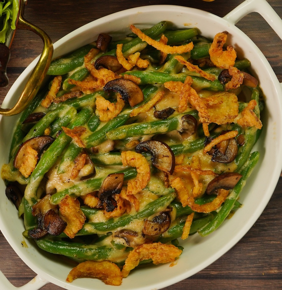 Green beans with mushrooms and onions in casserole dish, a vegan twist on a holiday staple recipe