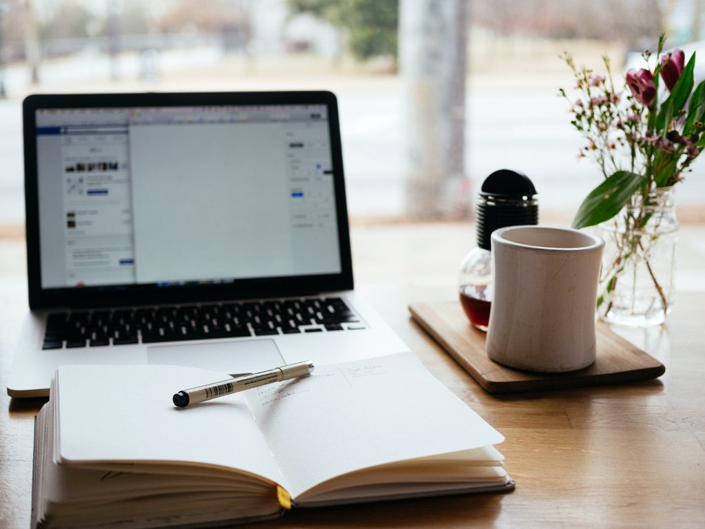 Notebook, laptop and coffee on desk