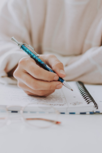 Person writing down on a notebook.