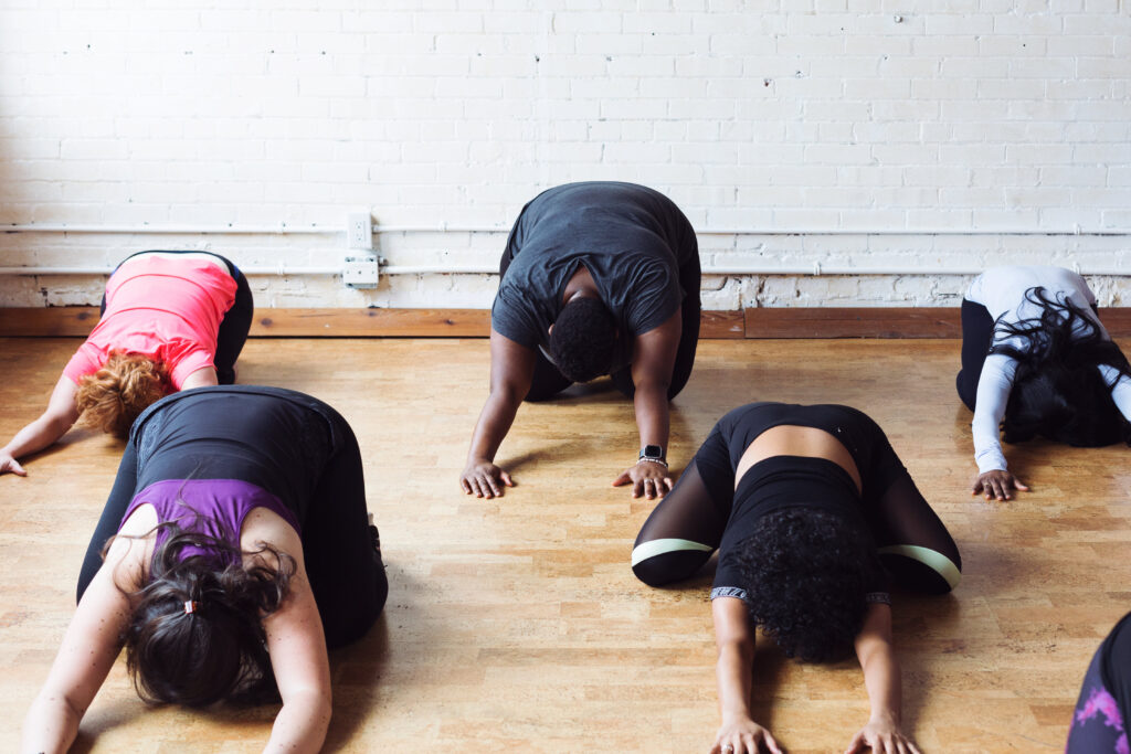 Yoga class performing child's pose.