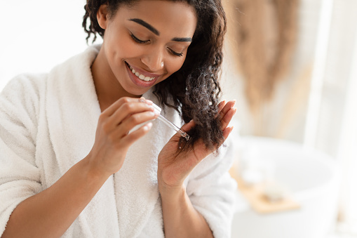 woman taking care of her natural hair by oiling it