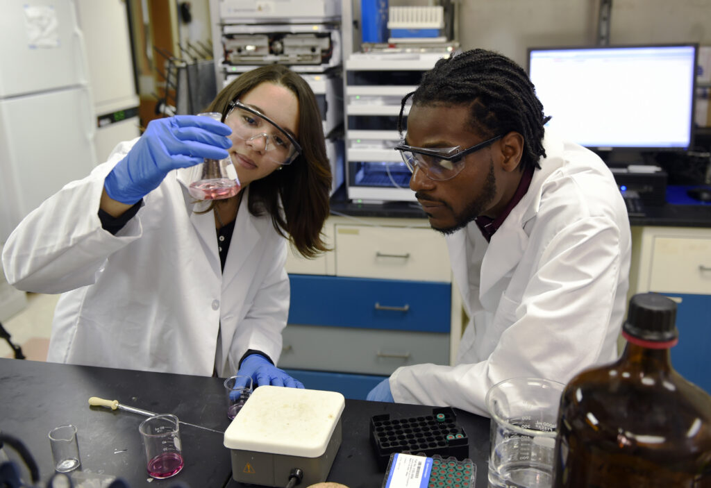 HBCU Morgan State student eyes beaker at the Naval Research Laboratory
