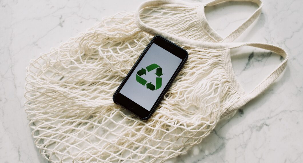 https://www.pexels.com/photo/mobile-phone-with-green-recycling-sign-and-mesh-bag-3850512/