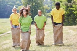 How to Develop Leadership Skills in Employees - Employees in a team building exercise - potato sack race