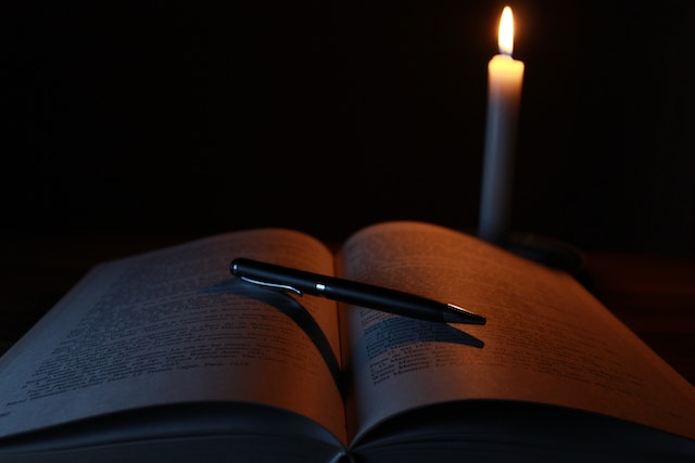 book in dark by candlelight