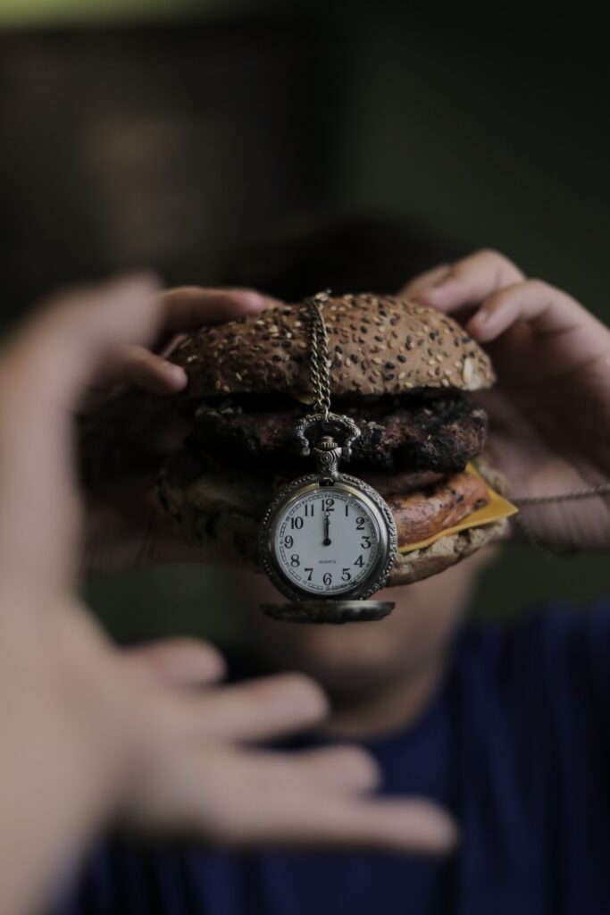 Healthy eating made simple by slowing down your meal. Burger with a watch.