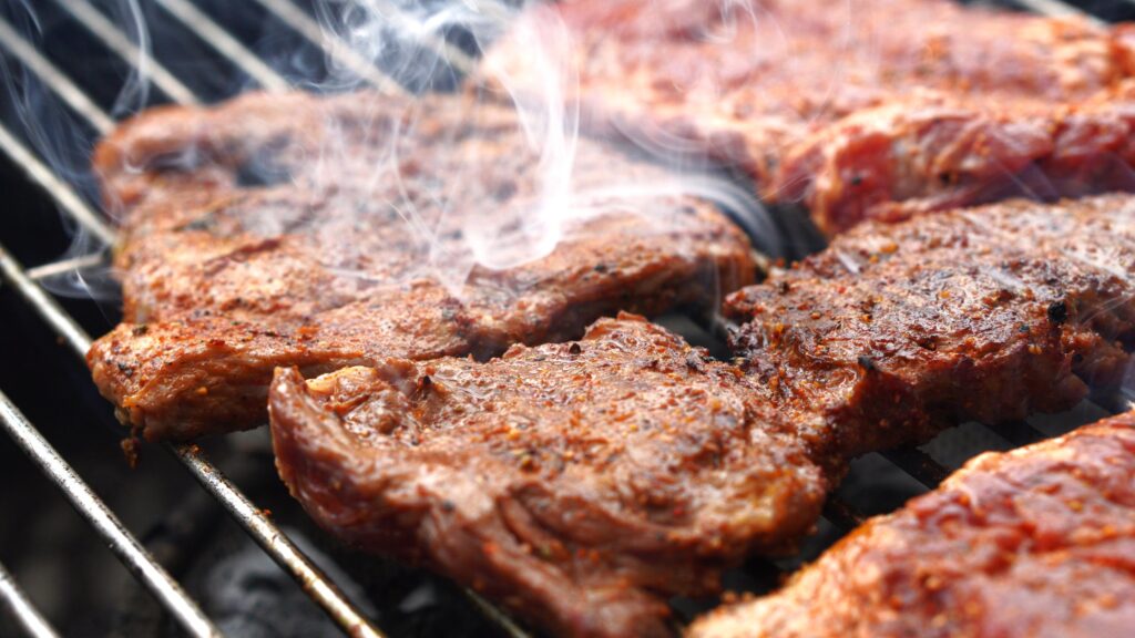 Meats smoking on a grill