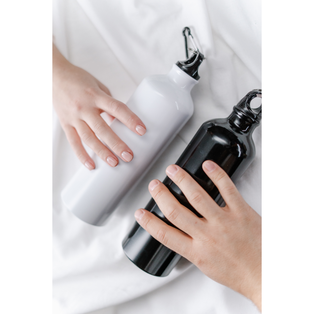 two hands holding metal water bottles
