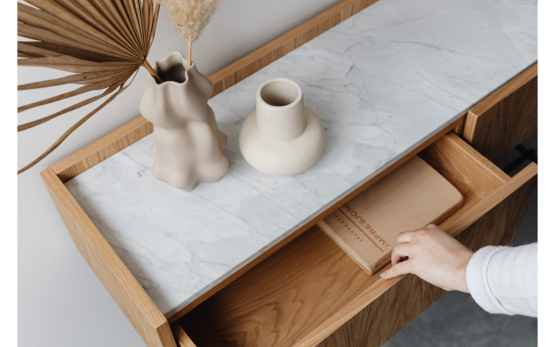 Decorative- someone's hand pulling a drawer open with simple vases on the counter