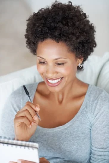 Black woman with smile making checklist