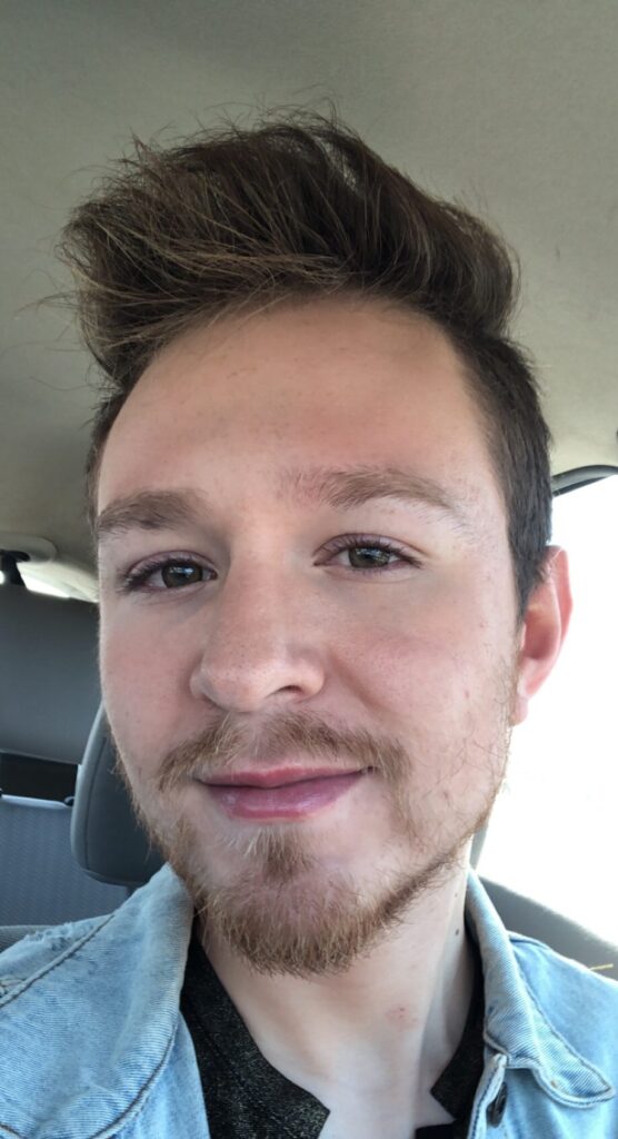 Picture of myself demonstrating makeup for men's acne with a caption asking if you can tell I'm wearing makeup. Sitting in my car with natural sunlight. 