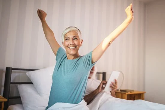 Woman stretching her arms waking up from bed
