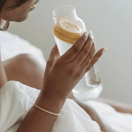 Woman hand holding bottle of water with lemon
