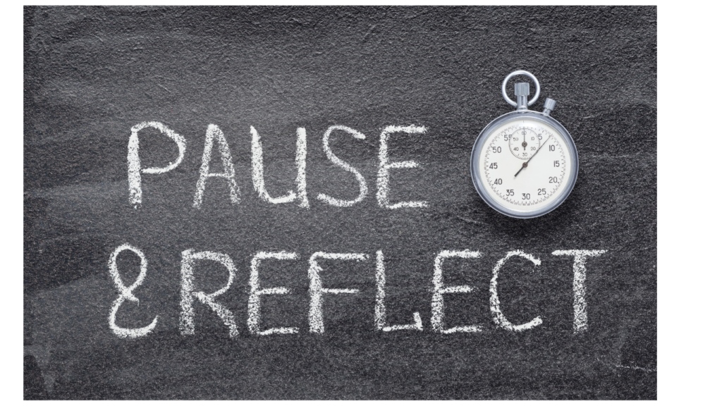 Chalkboard with pause and reflect written and a stopwatch 