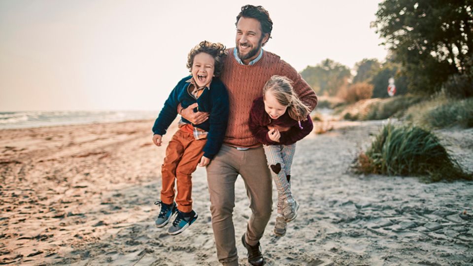 Dad on the beach with kids dressed well