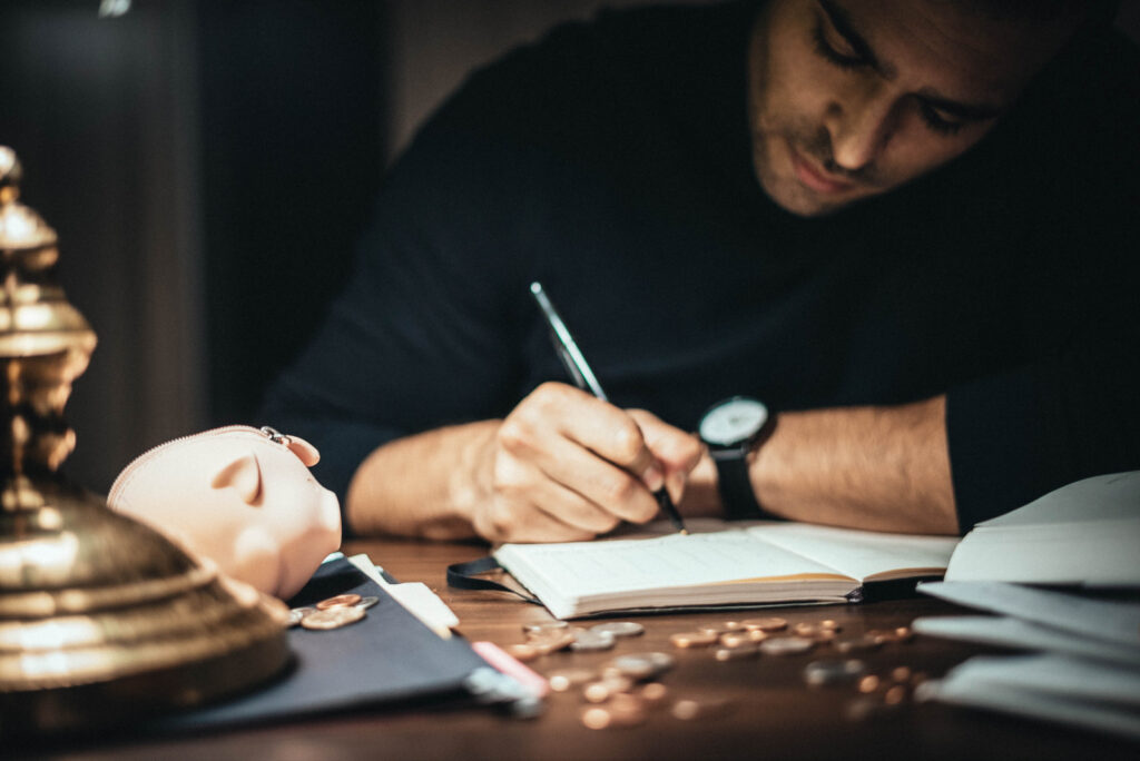 Man writing in a notepad. One of the great ways to improve time management is to begin by writing down your tasks.
