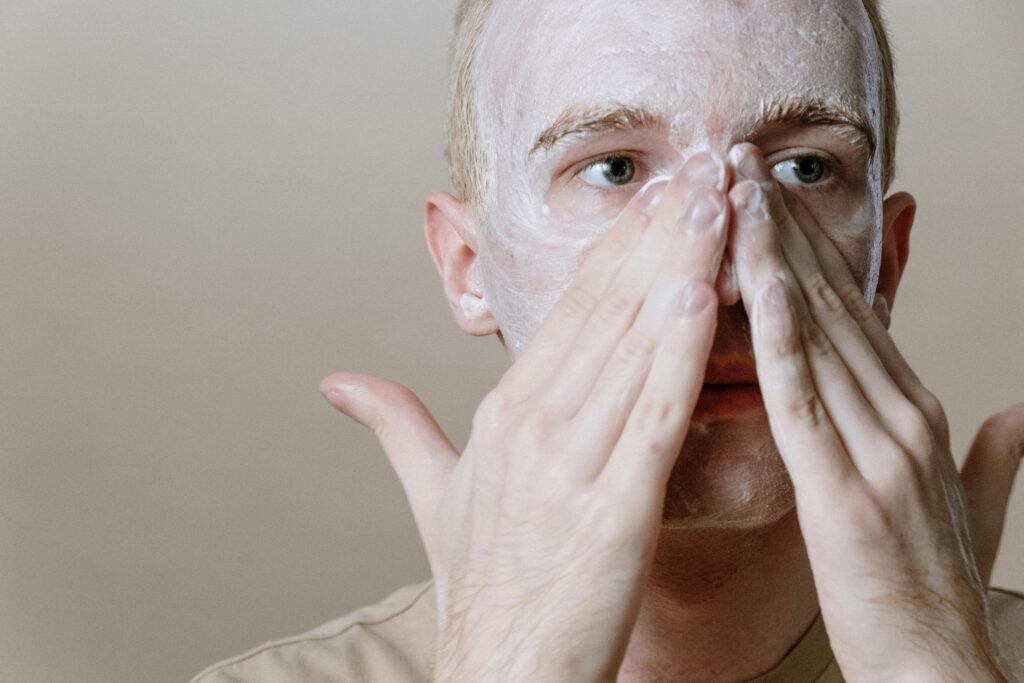 Man Rubbing In Face Mask to Skin