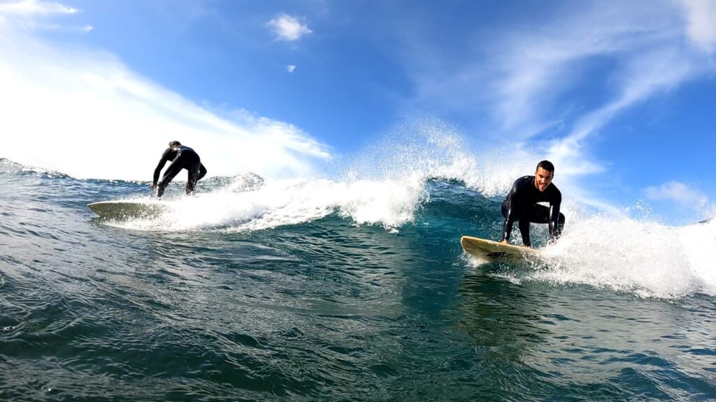 Two surfers taking the same wave but each one is going a different way. (Canary Islands)