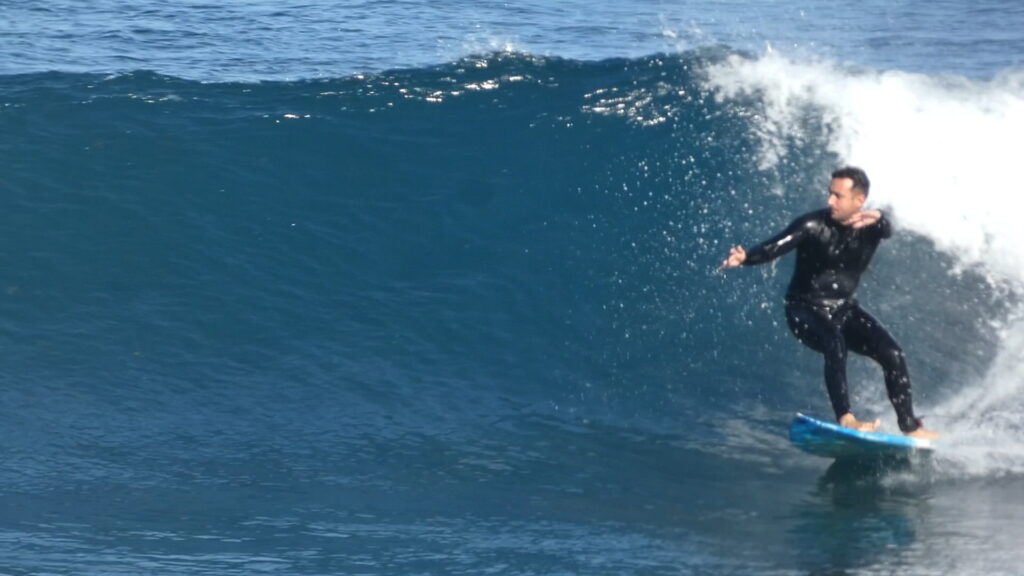 Goofyfoot surfer trying to balance with his arms while he is surfing. This is a key step to learn how to surf properly. (Canary Islands)