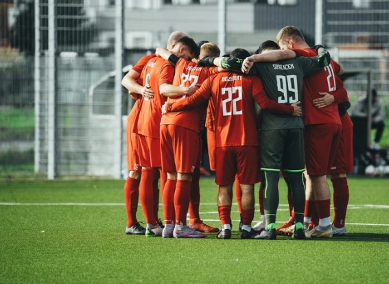 men's team huddled together on soccer field