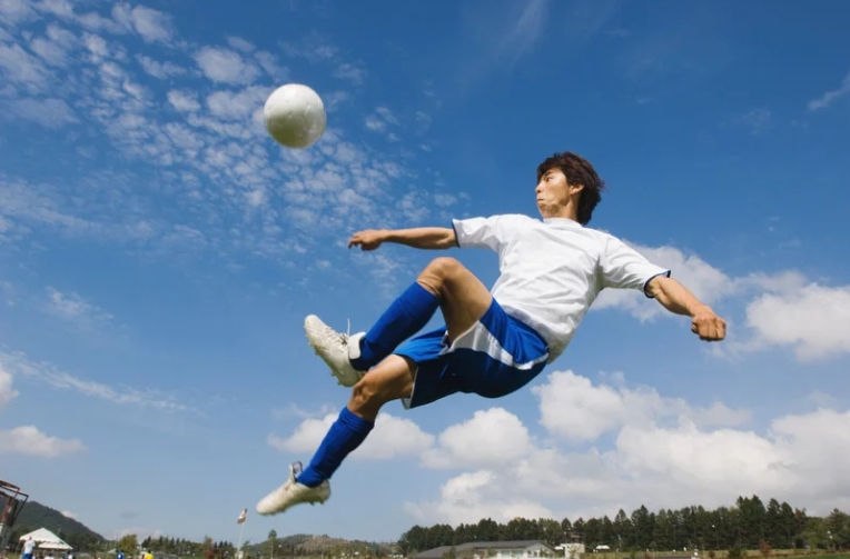 Man kicking soccer ball with power