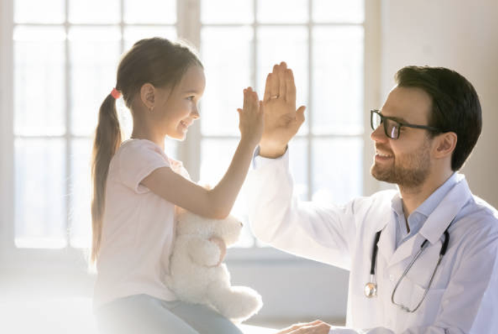 A child high-fiving a doctor