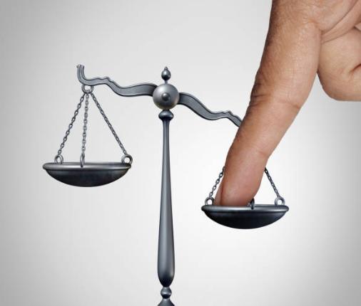 Scale of justice being weighed down by a finger Indicating that injustice is a reason for tuberculosis